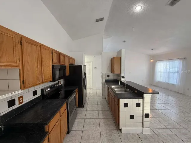 a kitchen with stainless steel appliances a stove a sink and a refrigerator