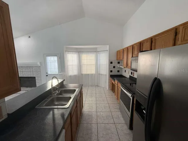 a kitchen with granite countertop a sink stove and refrigerator