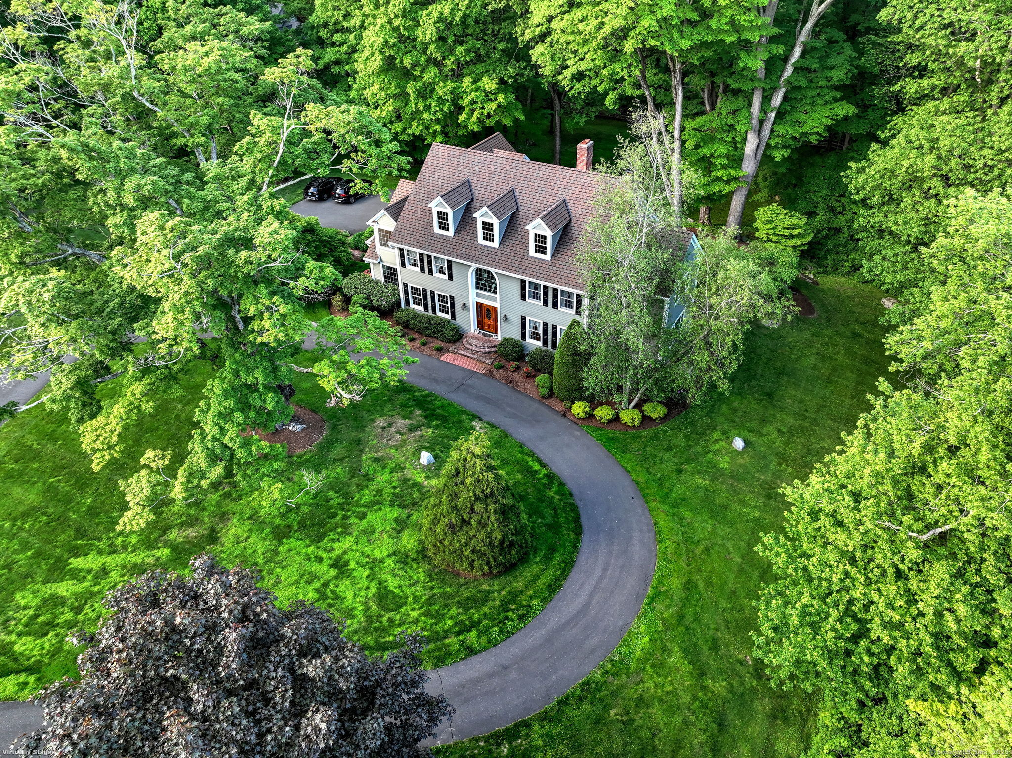 a aerial view of a house with a yard and large trees
