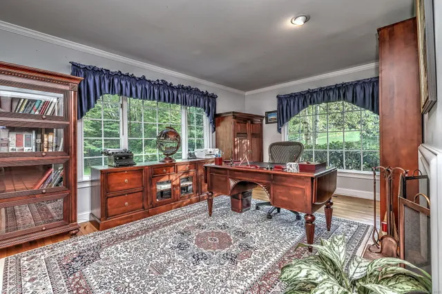 a living room with furniture a floor to ceiling window and a rug