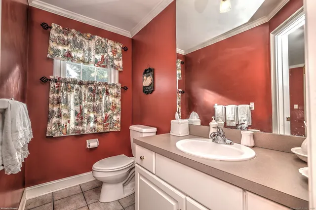a bathroom with a granite countertop sink toilet and mirror