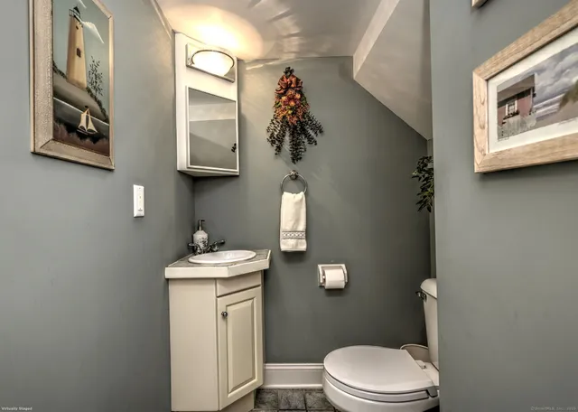 a bathroom with a toilet a sink and mirror