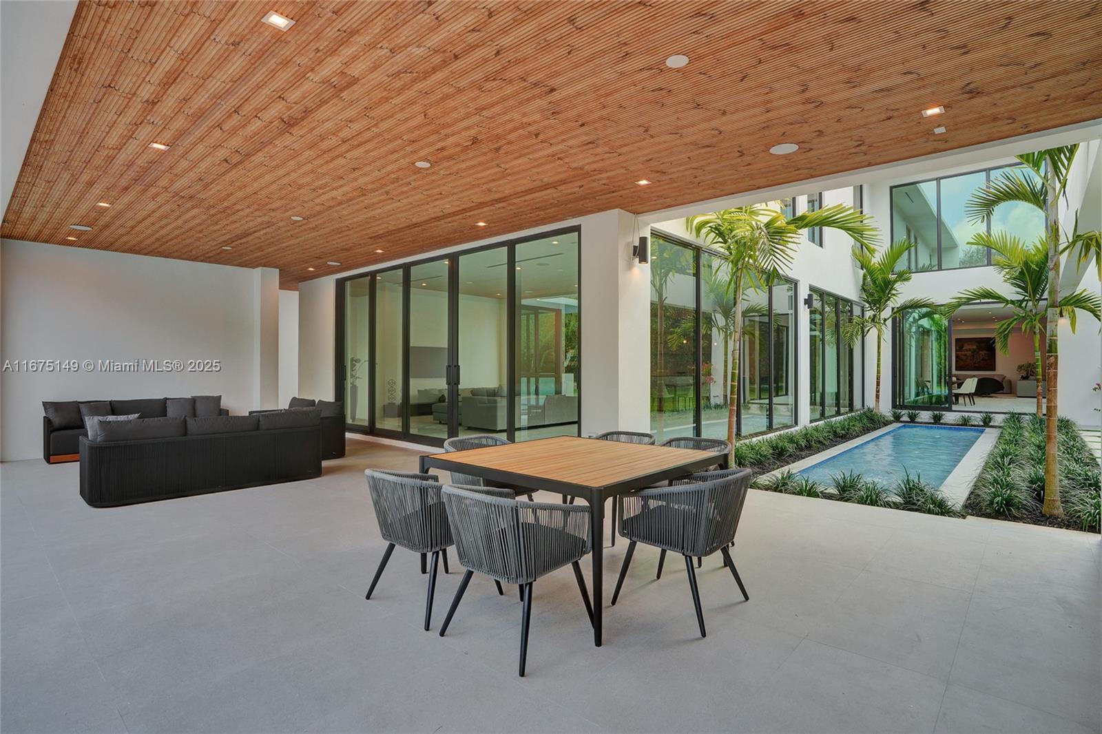 6350 Southwest 112th Street Pinecrest, FL 33156 - Photo 28 of 88 a patio with yard glass top table and chairs
