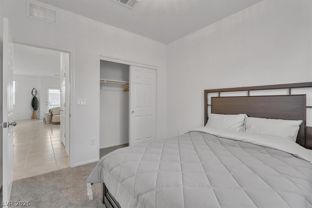635 Bellus Place Henderson, NV 89015 - Photo 22 of 37 Bedroom featuring light colored carpet, a closet, and light tile patterned floors