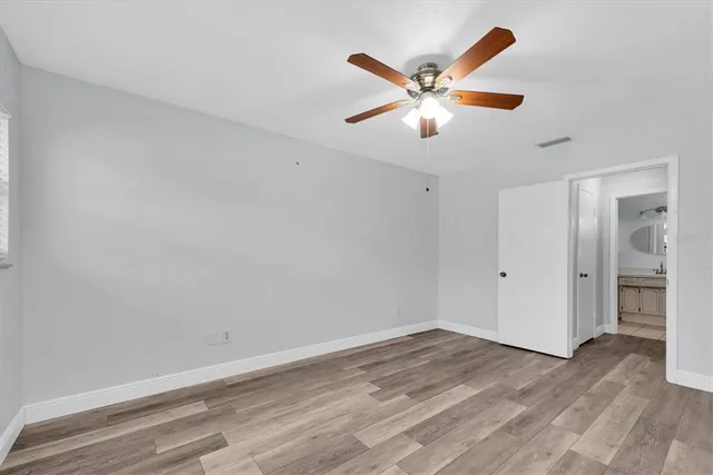 a view of a room with wooden floor and ceiling fan
