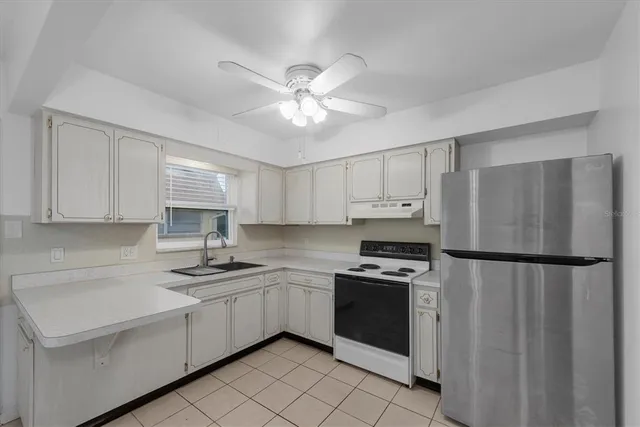 a kitchen with cabinets stainless steel appliances and a window