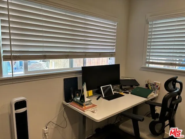 a view of a workspace with furniture and a window