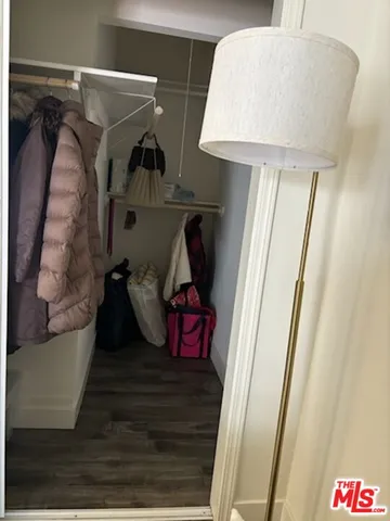 a view of walk in closet with clothes and shoes