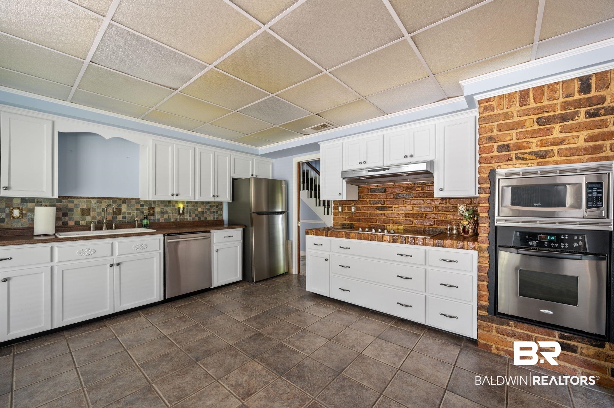 950 Walter Smith Road Mobile, AL 36695 - Photo 13 of 51 Kitchen featuring appliances with stainless steel finishes, a sink, dark countertops, a drop ceiling, and white cabinets