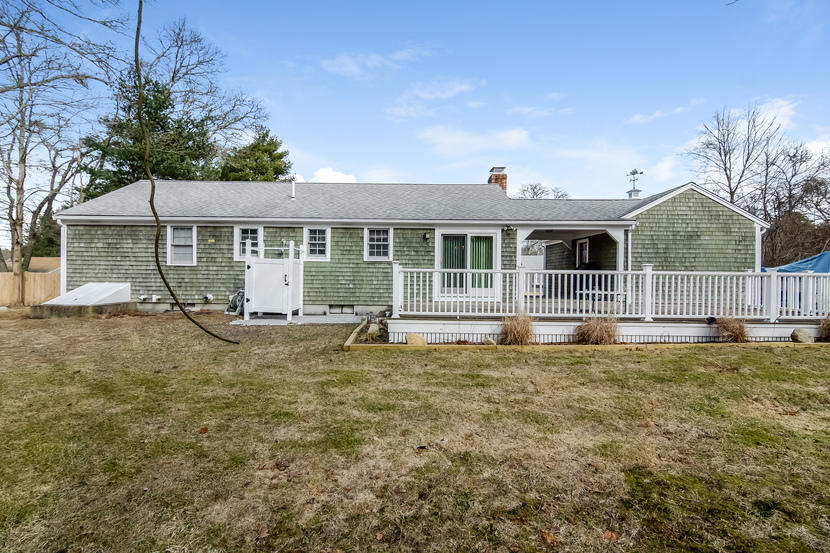 24 Stephen Road Bourne, MA 02532 - Photo 18 of 20 a white house with a small yard and large trees