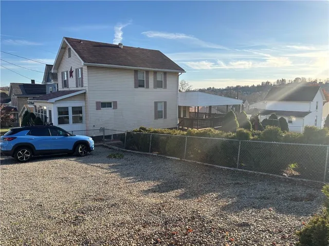 a view of a house with a car parked in front of it