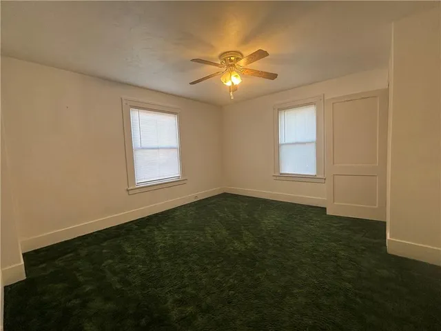 an empty room with closet and fan