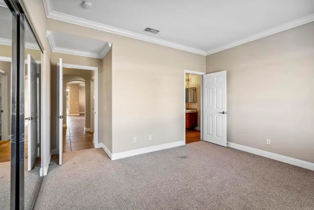 a view of an empty room with closet and a window
