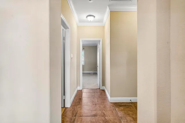 a view of a hallway with wooden floor and a bathroom