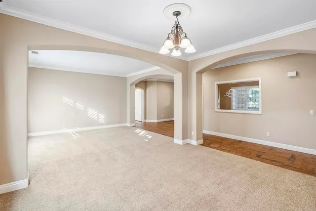 a view of a livingroom with a chandelier fan and windows