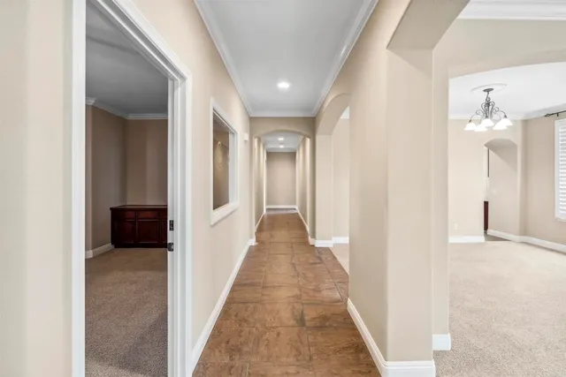 a view of a hallway with wooden floor and a living room