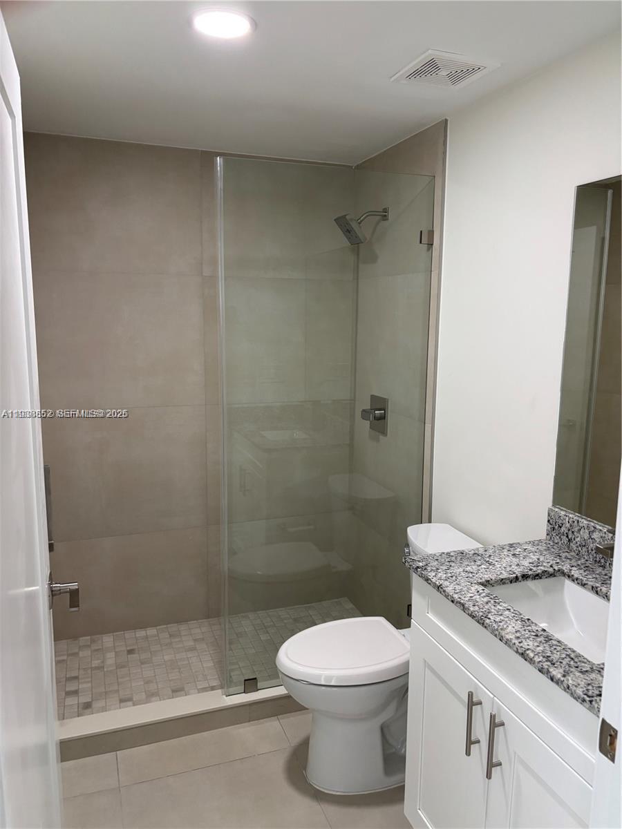 310 East 7th Street, Unit 203 Hialeah, FL 33010 - Photo 12 of 13 a bathroom with a granite countertop sink a toilet and shower