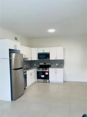 a kitchen with a refrigerator and a stove