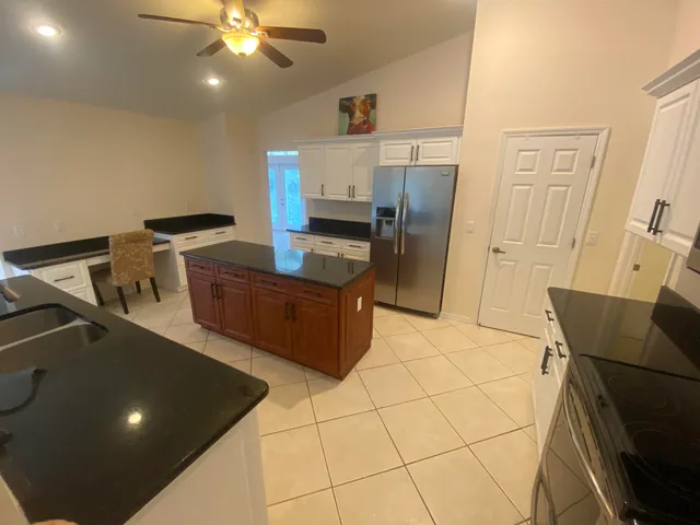 a view of kitchen with furniture and refrigerator