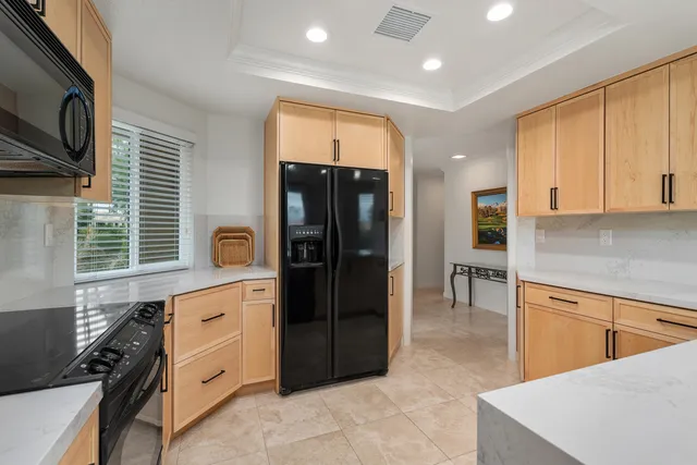 a kitchen with stainless steel appliances kitchen island granite countertop a refrigerator and a stove top oven