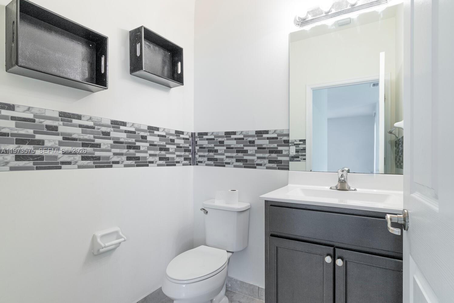 516 Southeast 35th Terrace Homestead, FL 33033 - Photo 21 of 25 a bathroom with a toilet sink and mirror