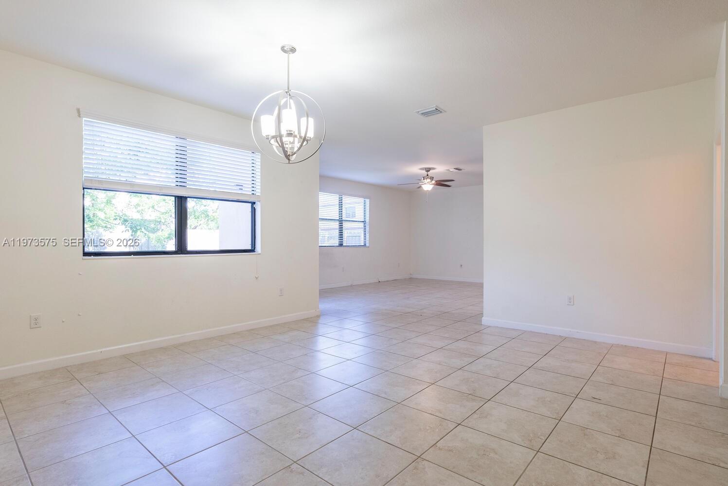 516 Southeast 35th Terrace Homestead, FL 33033 - Photo 6 of 25 an empty room with windows and chandelier