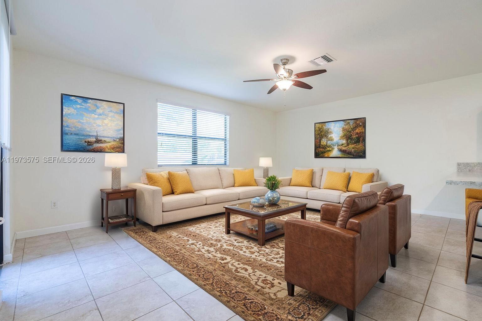 516 Southeast 35th Terrace Homestead, FL 33033 - Photo 7 of 25 a living room with furniture a ceiling fan a lamp and a window