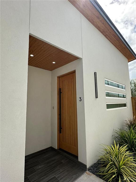 322 East Rogers Road, Unit 2 Edinburg, TX 78541 - Photo 1 of 1 Modern exterior with wood-finish soffits, corrugated metal siding, and a smooth stucco finish