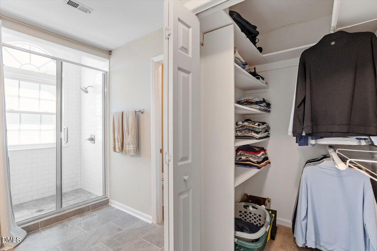 8321 Hempshire Place, Unit 103 Raleigh, NC 27613 - Photo 20 of 25 a view of walk in closet with clothes and shoes