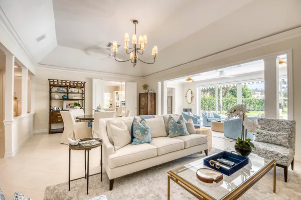 a living room with furniture chandelier and a large window