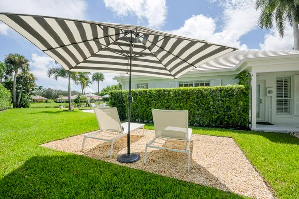 a view of a patio with a table and chairs under an umbrella