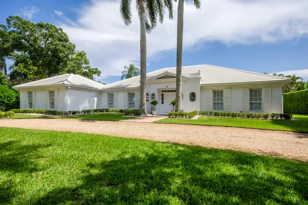 a front view of a house with a garden and yard