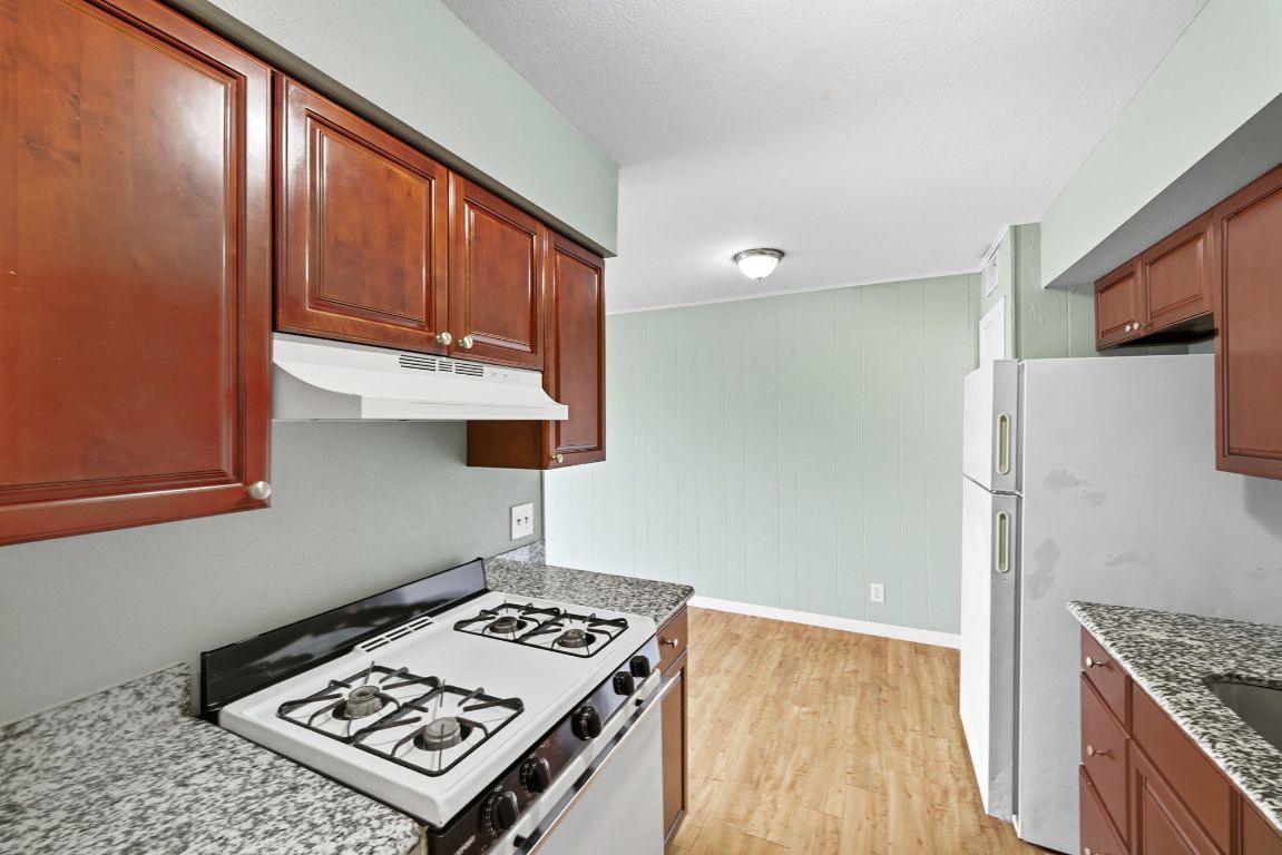 2208 Mission Hill Drive, Unit 103 Austin, TX 78741 - Photo 14 of 26 a view of kitchen island with stainless steel appliances stove refrigerator and cabinets