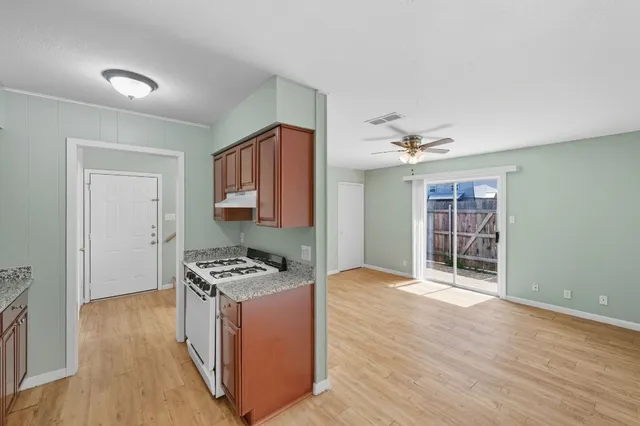 a kitchen with granite countertop a sink stove and cabinets