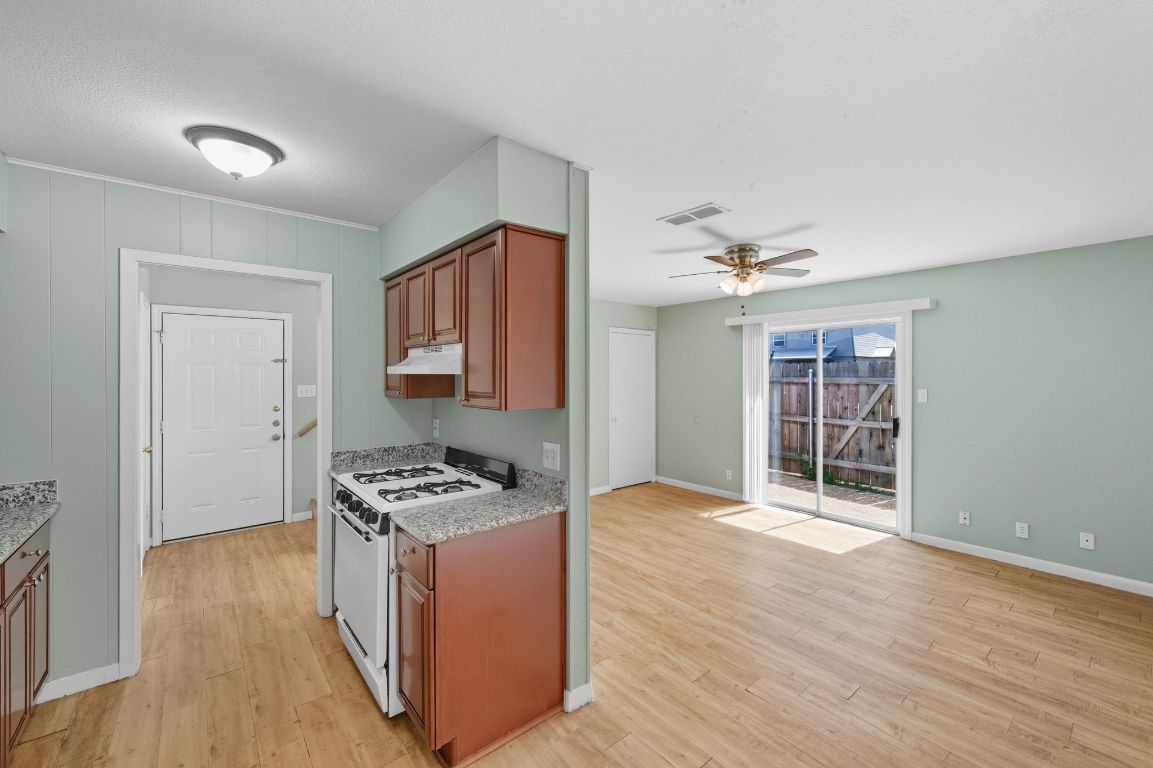 2208 Mission Hill Drive, Unit 103 Austin, TX 78741 - Photo 16 of 26 a kitchen that has a microwave a stove and wooden floor