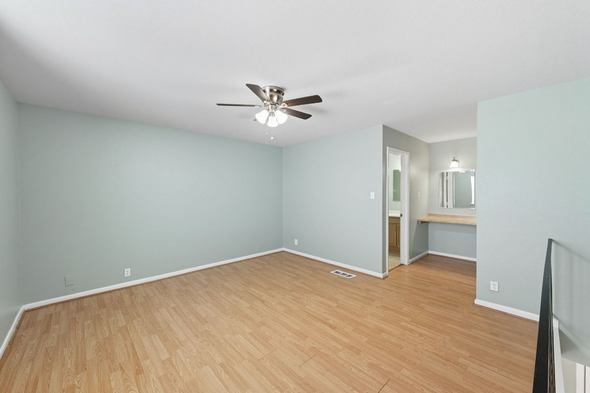 2208 Mission Hill Drive, Unit 103 Austin, TX 78741 - Photo 18 of 26 wooden floor in an empty room with a window