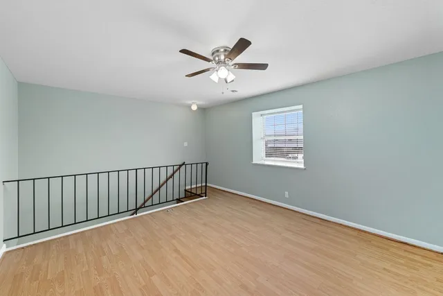a view of a room with wooden floor and ceiling fan