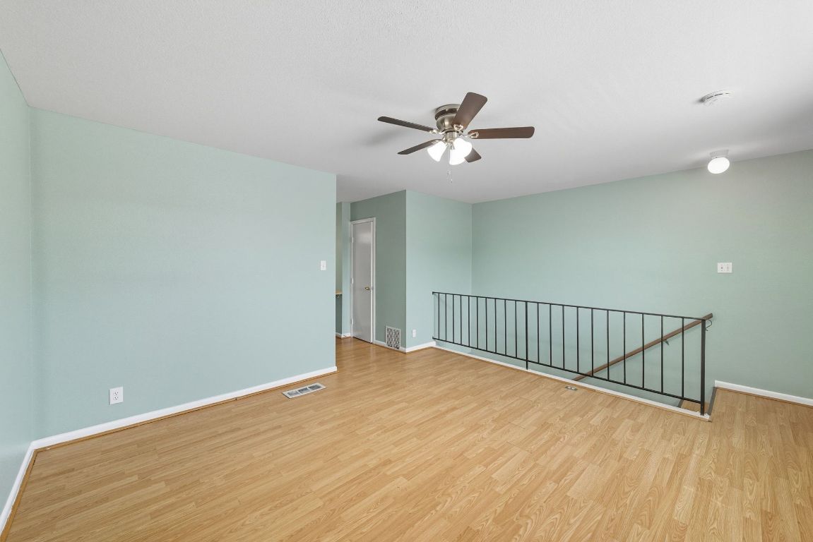2208 Mission Hill Drive, Unit 103 Austin, TX 78741 - Photo 20 of 26 a view of a room with wooden floor and ceiling fan