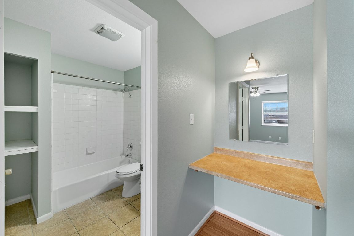 2208 Mission Hill Drive, Unit 103 Austin, TX 78741 - Photo 21 of 26 a bathroom with a granite countertop sink mirror vanity and toilet