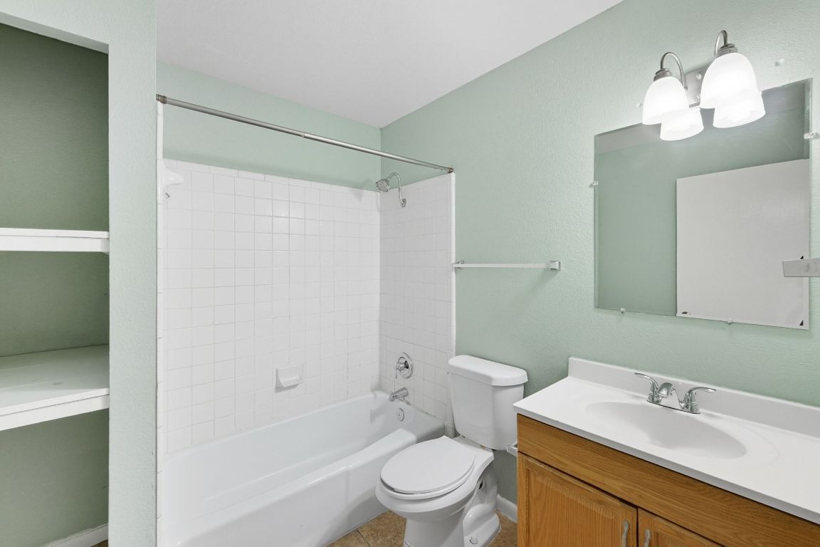 2208 Mission Hill Drive, Unit 103 Austin, TX 78741 - Photo 22 of 26 a bathroom with a sink a toilet and a mirror