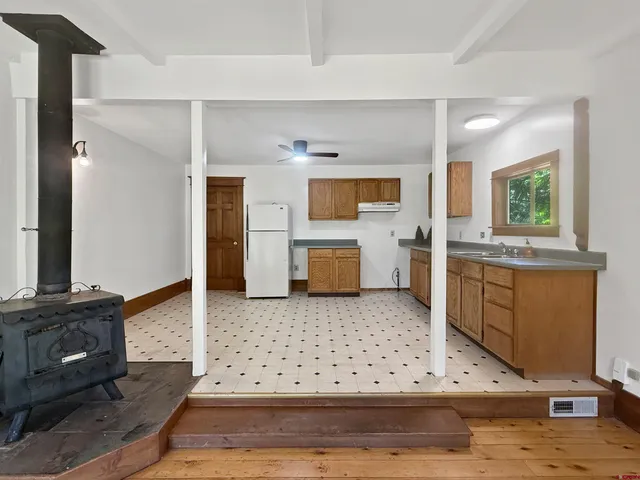 a living room with stainless steel appliances kitchen island granite countertop furniture and a fireplace