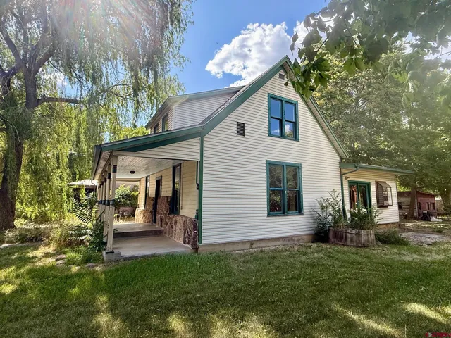 a view of a house with backyard and a tree