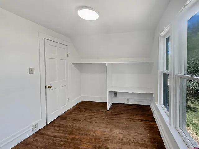 a view of a room with wooden floor and white walls