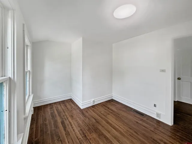 a view of a room with wooden floor and white walls