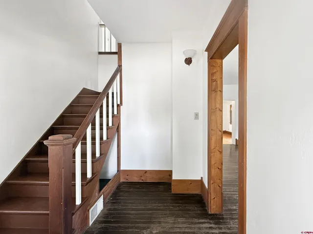 a view of a hallway with wooden floor and entryway