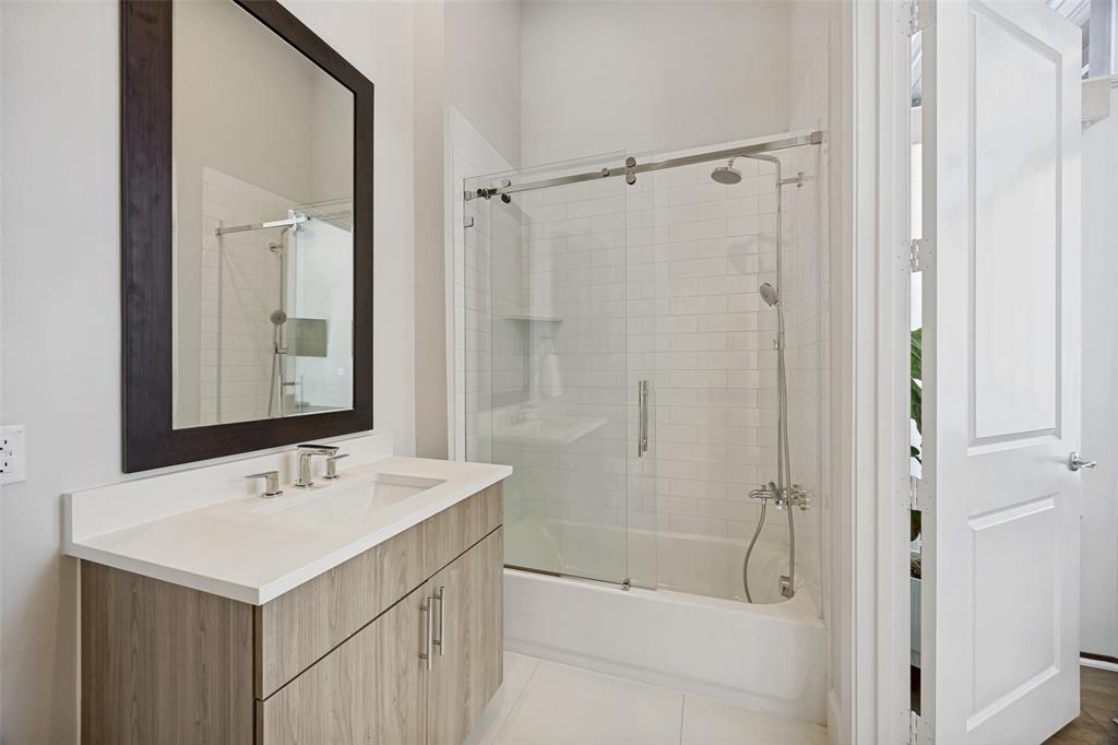 15015 Oak Street Addison, TX 75001 - Photo 11 of 33 a bathroom with a sink a mirror and a shower