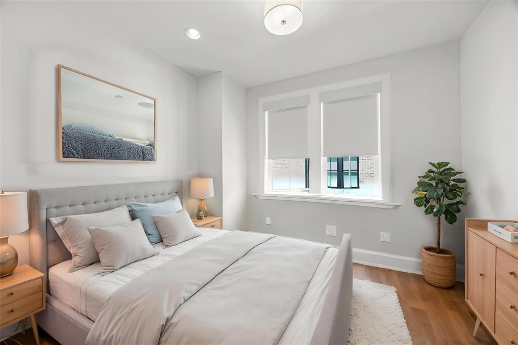 15015 Oak Street Addison, TX 75001 - Photo 23 of 33 a bedroom with a large bed and a potted plant