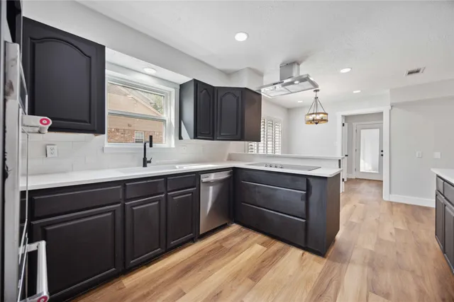 a kitchen with a sink cabinets and wooden floor