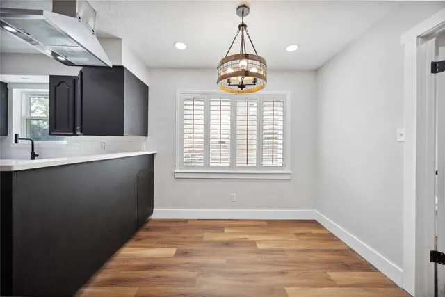 a view of an empty room with window and wooden floor