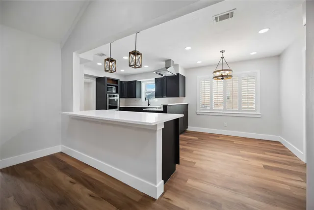 a kitchen with kitchen island white cabinets and window